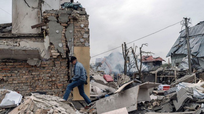 A resident walks over building rubble following a Russian missile attack in Kyiv
