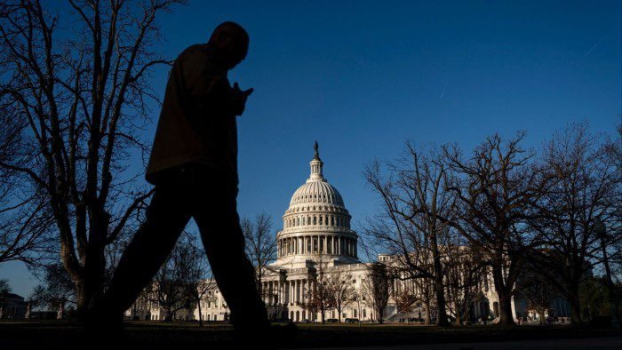 A person walks in front of the US Capitol building in Washington, DC