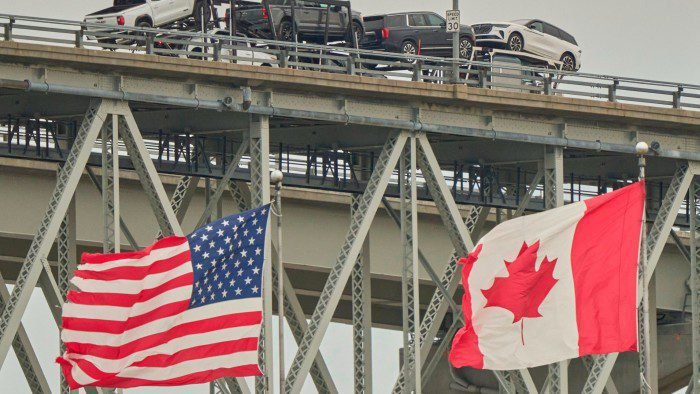 A truck with vehicles crosses the Blue Water Bridge border crossing into the US from Sarnia, Ontario, Canada