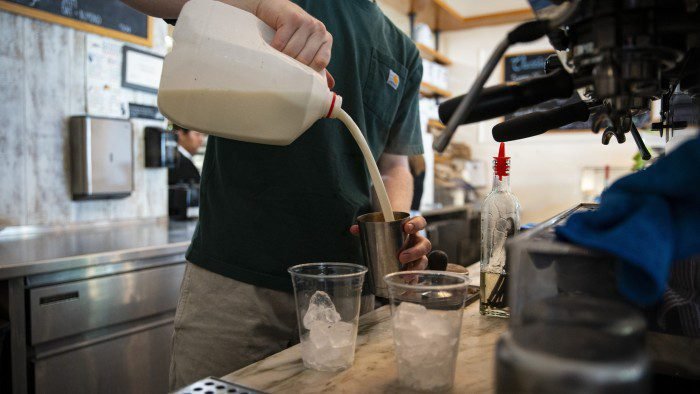 A barista pours milk for an iced latte at a coffee shop in the Union Market district in Washington